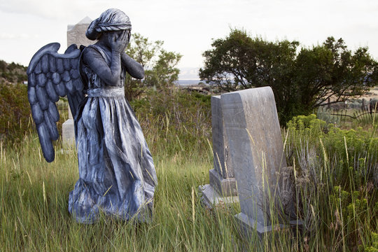 Girl wearing an angel costume in an old grave yard