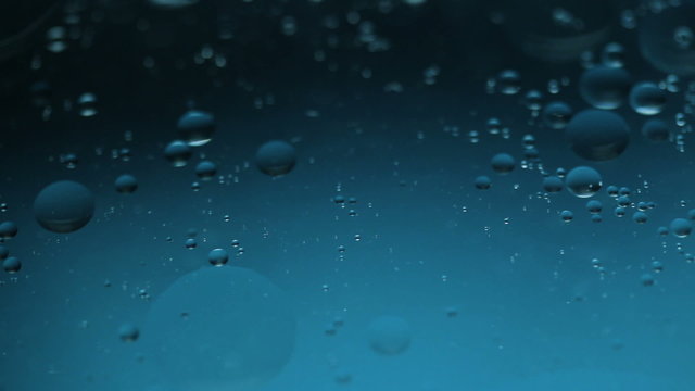 Abstract close-up of floating oil drops on water surface