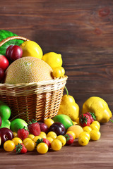 Assorted of fresh fruits in wicker baskets on wooden background