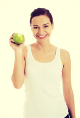 Happy brunette woman holding an apple