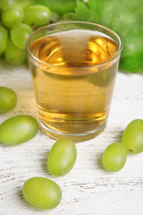 Glass of grape juice on wooden table, closeup