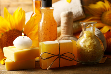 Spa treatments and sunflower on wooden background