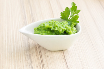 Broccoli puree in a white bowl.