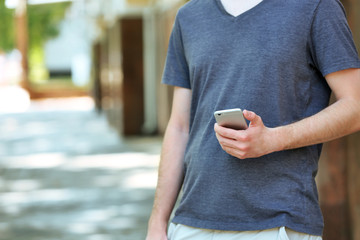 Man holding smart mobile phone outdoors