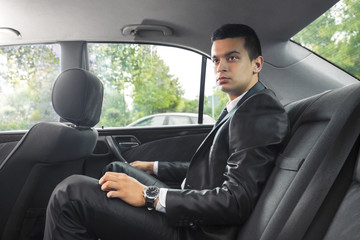 Fototapeta na wymiar Young businessman traveling to work by taxi