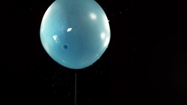 Water balloon falling on black background