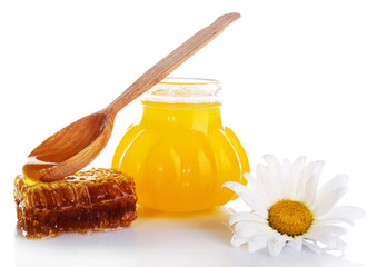 Pot of honey, wooden spoon and honeycomb isolated on white