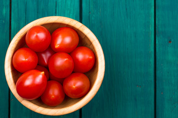 Tomatoes in a plate and on a wooden table