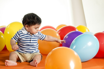 Fototapeta na wymiar happy boy with colorful balloons over white