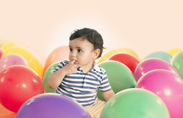 Fototapeta na wymiar joyful kid boy on birthday party with ballons warm filter applie
