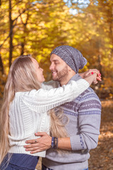 Young couple in love looking at each other in autumn park vintage stylized