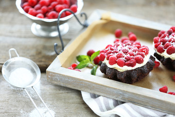 Sweet cakes with raspberries on wooden table background