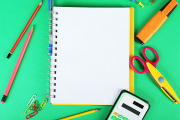 Office and student tools on green background closeup