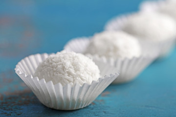 Coco sweets on color wooden background