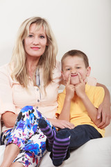 Happy family. Mother and kid on sofa at home.
