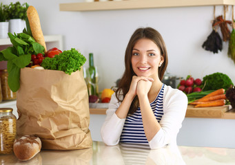 Young woman sitting in kitchen at home