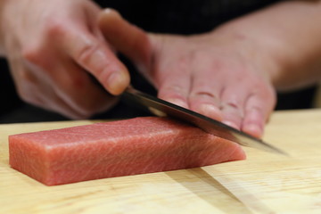 hand of japanses sushi chef slice a sashimi - obrazy, fototapety, plakaty