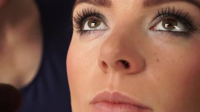 Makeup artist applying rouge to model face 4K