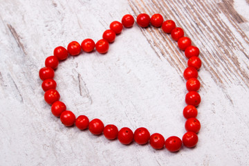 Heart of red viburnum on old wooden background