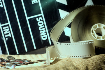 Naklejka premium Cinema clapper and video film negative movie on a rough cloth.