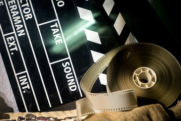 Obraz premium Cinema clapper and video film negative movie on a rough cloth