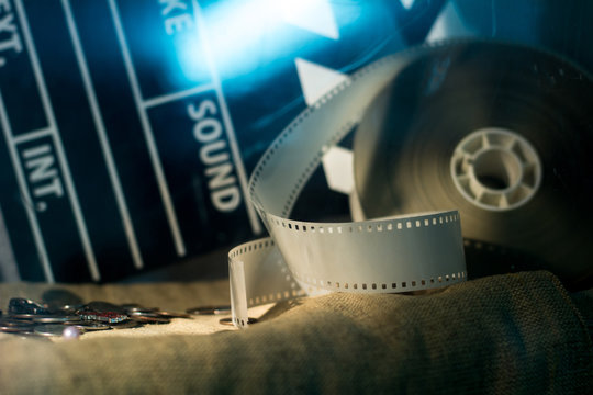 Cinema clapper and video film negative movie on a rough cloth.
