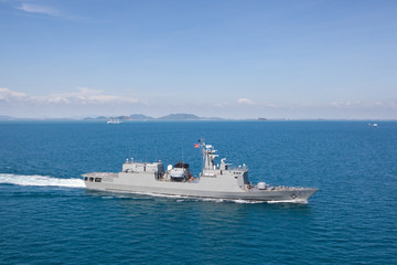 Grey modern warship sailing in still water