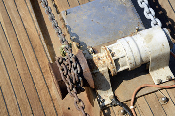 Anchor winch with chain on a deck.

