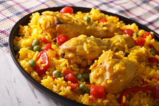 Paella with chicken drumsticks and vegetables close-up. horizontal
