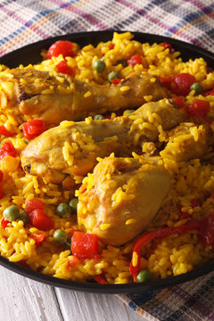 Paella with chicken legs and vegetables close-up. Vertical
