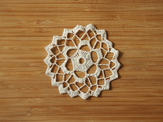 Crocheted snow flake on a wooden background.