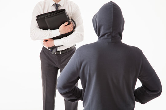 Businessman trying to hide his briefcase by unknown man