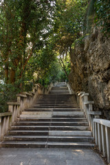 Fototapeta na wymiar Long flight of stony steps to the Marjan hill surrounded by trees and rock in Split, Croatia.