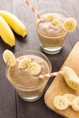 Banana smoothie on wooden background. Top view