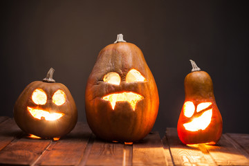 Jack o lanterns Halloween pumpkin face on wooden background