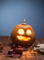 Jack o lanterns Halloween pumpkin face on wooden background