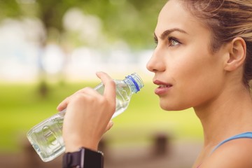 Close-up of jogger woman drinking water 