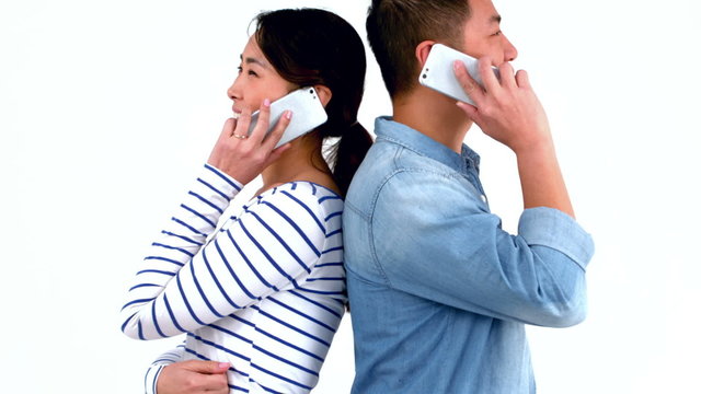 Smiling couple having phone calls back to back