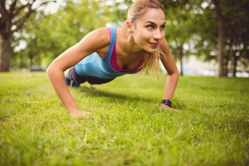 Smiling woman exercising on grass 