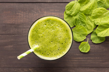 Healthy green smoothie on rustic wood background