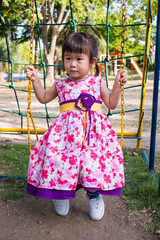 Adorable girl fun on swing in the park. 