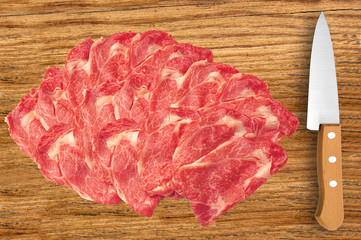 raw meat and knife on cutting wooden board