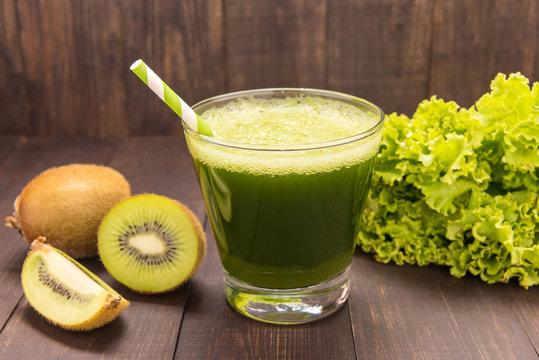 Healthy green smoothie with kiwi, lettuce on rustic wood backgro