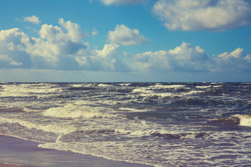 Marine landscape with stormy sea and blue cloudy sky
