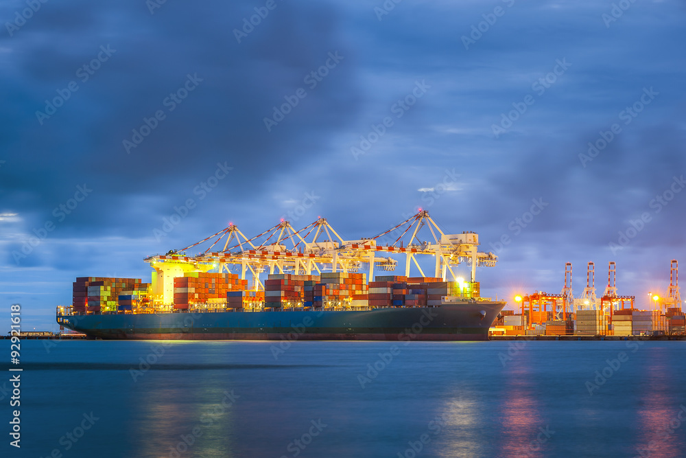 Wall mural container cargo freight ship with working crane bridge in shipyard at dusk for logistic import expor