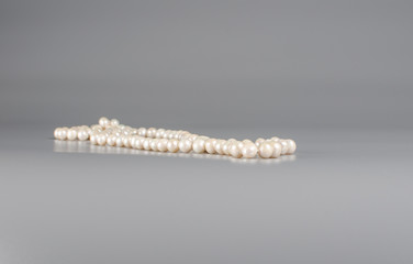 pearl necklace on gray background