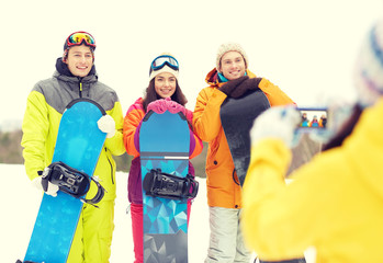 happy friends with snowboards and smartphone