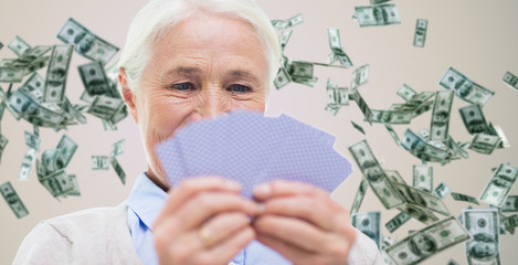 close up of happy senior woman playing cards
