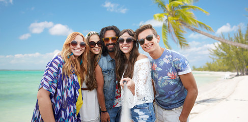 happy hippie friends with selfie stick on beach