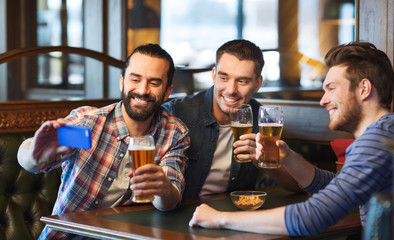 friends taking selfie and drinking beer at bar